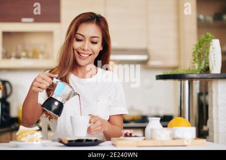 Donna che si versa il caffè Foto Stock