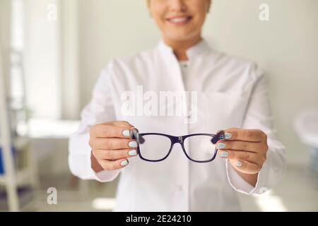 Un ottico professionista sorridente disposto ad aiutare e a chiederti di farlo prova con i nuovi occhiali Foto Stock