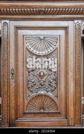 Parte della cucina antica credenza come esempio di bella incisione su legno come sfondo. Foto Stock