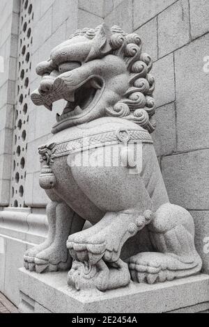 Tradizionale statua di leone cinese in pietra bianca all'ingresso di Tempio buddista nella città di Hong Kong Foto Stock