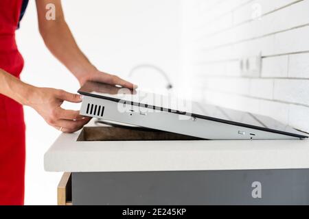 Installazione di fornelli a induzione piano di cottura o da parte di un maestro. Foto Stock
