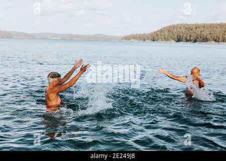 Coppia che si spruzzi in mare Foto Stock