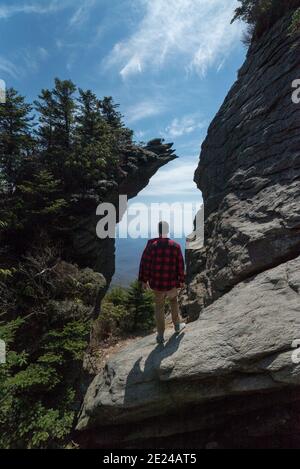 Un uomo su una collina rocciosa Foto Stock