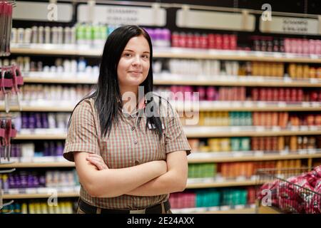 Assistente al negozio femminile nel supermercato Foto Stock