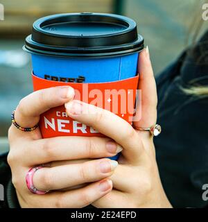 Londra UK, Close Up of an Anonymous Woman Holding A Disposable Cup of Cafe Nero Takeaway Coffee Foto Stock