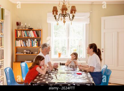 Carte da gioco per la famiglia al tavolo Foto Stock