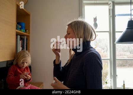 Donna che utilizza l'asma inalatore Foto Stock
