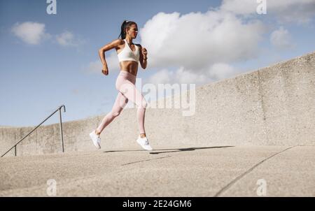 Atleta che corre al mattino. Donna in forma fisica indossare allenamento all'aperto. Foto Stock