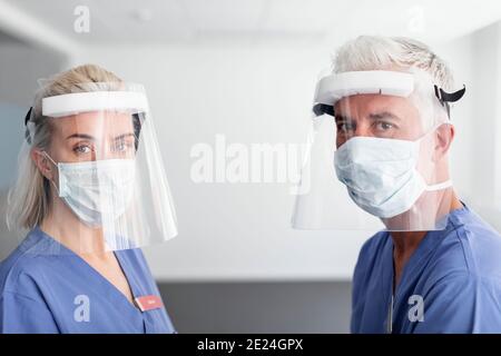 Medici che indossano dispositivi di protezione individuale Foto Stock