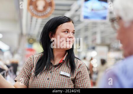 Assistente al negozio femminile nel supermercato Foto Stock