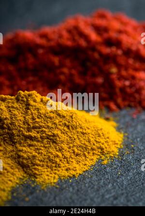 Spezie luminose e colorate sullo sfondo di pietra nera. Spezie ed erbe diverse per lo sfondo. Foto Stock
