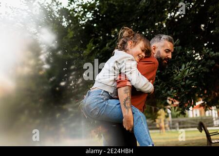 Padre dando figlia piggyback ride Foto Stock