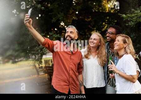 Sorridente amici prendendo selfie Foto Stock