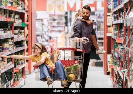 Padre con le figlie che fanno shopping nel supermercato Foto Stock