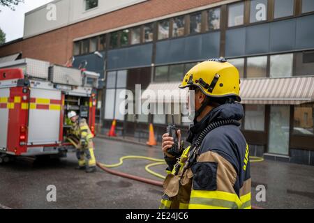 Pompiere che parla tramite walkie talkie Foto Stock