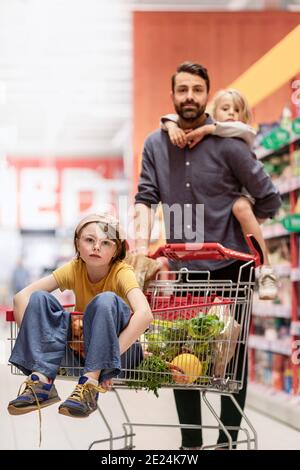 Padre con le figlie che fanno shopping nel supermercato Foto Stock