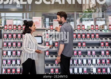 Coppia di fronte ai lettori di codici a barre nel supermercato Foto Stock