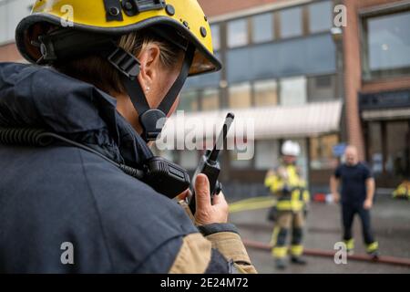 Pompiere che parla tramite walkie talkie Foto Stock