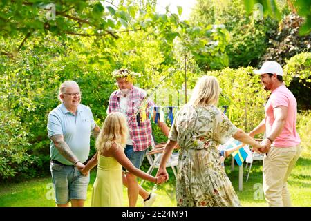 La famiglia balla in giardino intorno a maypole Foto Stock