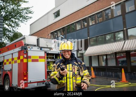 Pompiere che parla tramite walkie talkie Foto Stock