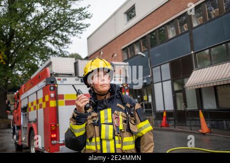 Pompiere che parla tramite walkie talkie Foto Stock