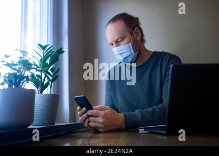 Uomo a casa con maschera Foto Stock