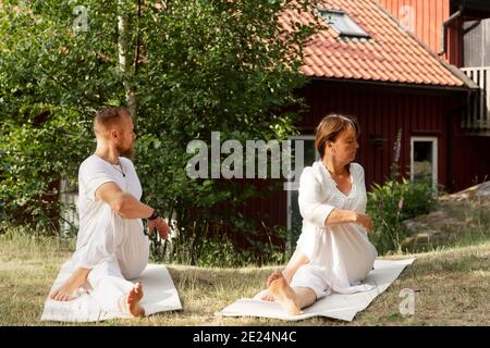 L'uomo e la donna praticano lo yoga in estate Foto Stock