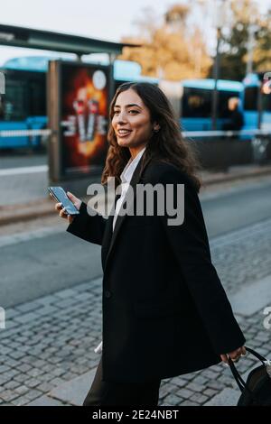 Sorridente giovane donna azienda telefono cellulare Foto Stock