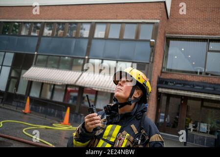 Pompiere che parla tramite walkie talkie Foto Stock