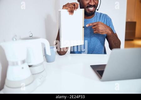 Freelance afro-americano che raccoglie un libro da record Foto Stock