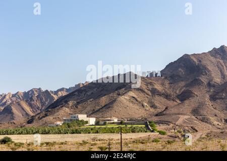 Le montagne Hajar si trovano ad Hatta, con un grande cartello hatta in stile hollywoodiano in cima alla collina, negli Emirati Arabi Uniti. Foto Stock