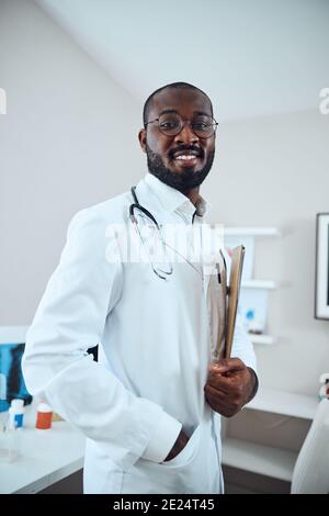 Professionista medico sicuro con gli appunti e la mano in tasca Foto Stock