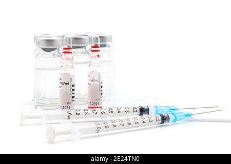 Siringhe mediche e aghi per iniezione ipodermica le siringhe e gli aghi sono senza cappuccio. La siringa centrale e il flaconcino sinistro sono il punto focale. Foto Stock