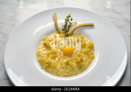 risotto con frittelle e uovo in piatto bianco su marmo vista dall'alto Foto Stock