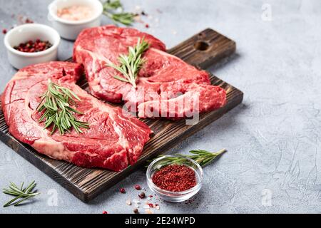 Due bistecche fresche di manzo prime Black Angus a base di carne cruda, Rib Eye, Denver, su tagliere di legno. Foto Stock