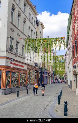 Bruxelles, Belgio - 20 luglio 2020: Persone che camminano attraverso una strada storica nel centro storico di Bruxelles Foto Stock