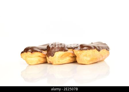 Tre eclair al cioccolato, primo piano, isolati su bianco. Foto Stock