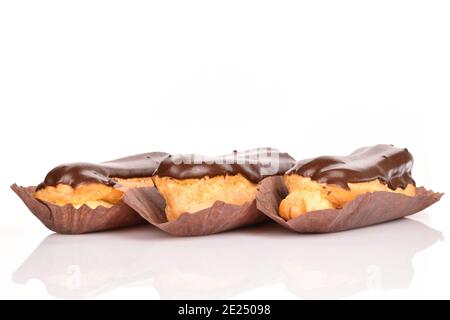 Tre eclair al cioccolato, primo piano, isolati su bianco. Foto Stock