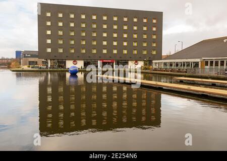 Walsall, West Midlands, Regno Unito. 12 gennaio 2021. Gli installatori di una boa di avvertimento di 6 piedi di diametro nel canale del bacino di Walsall nelle Midlands occidentali hanno chiesto di mantenere a galla l'allerta di acque profonde per altri cinque anni. Il canale e River Trust sostengono che la sfera blu gonfiata di 2 metri ha salvato molte vite nel corso dei mesi che è stato lì nel canale. Intorno al bacino del canale ci sono bar e ristoranti, così come la Walsall New Art Gallery, e i visitatori e i pub spesso confondono le alghe che crescono in estate per l'erba - con il risultato di alcune sorprese bagnate. Peter Lopeman/Alamy Live nuovo Foto Stock