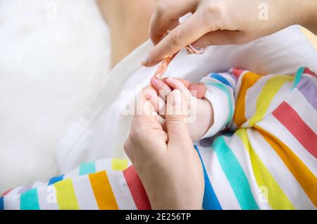 la madre taglia le unghie del bambino piccolo. Messa a fuoco selettiva. Bambino. Foto Stock