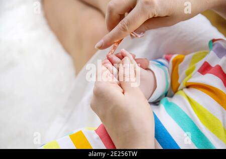 la madre taglia le unghie del bambino piccolo. Messa a fuoco selettiva. Bambino. Foto Stock