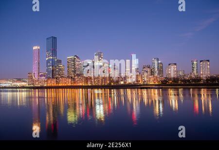 Londra, Inghilterra, Regno Unito - 9 gennaio 2021: Panorama del famoso quartiere finanziario Canary Wharf e del Tamigi illuminati di notte a Londra Foto Stock