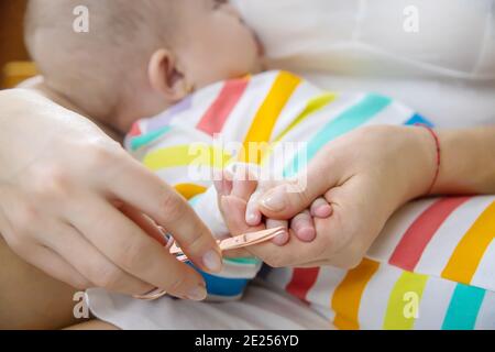 la madre taglia le unghie del bambino piccolo. Messa a fuoco selettiva. Bambino. Foto Stock