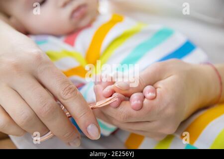 la madre taglia le unghie del bambino piccolo. Messa a fuoco selettiva. Bambino. Foto Stock