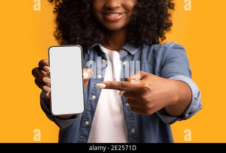 Donna nera che punta allo smartphone con schermo vuoto Foto Stock