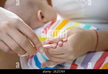 la madre taglia le unghie del bambino piccolo. Messa a fuoco selettiva. Bambino. Foto Stock