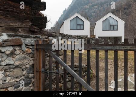 Casa bianca circondata da natura, foresta e nebbia in inverno. Edificio nella valle svizzera. Nessuno dentro Foto Stock
