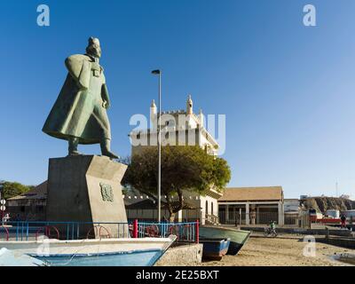 Barche da pesca tradizionali sulla spiaggia del porto e la statua di Diogo Alfonso, lo scopritore dell'isola. City Mindelo, un porto marittimo sull'isola Foto Stock