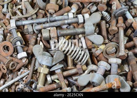 Sfondo di vecchi bulloni arrugginiti, viti, dadi, viti, staffe, vari dettagli in metallo Foto Stock