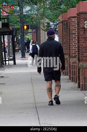 Uomo che cammina lungo Cincinnati Ohio Street con tatuaggio su entrambi zampe di vitello Foto Stock